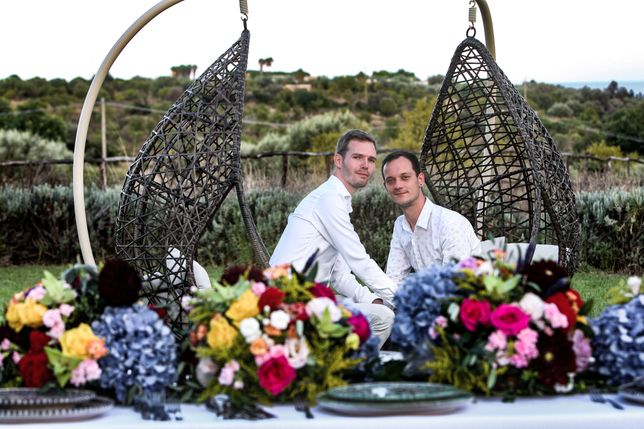 Wedding couple in the background behind a styled wedding table with vivid colours