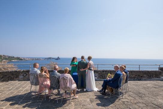 wedding couple with guests at wedding ceremony overlooking the sea